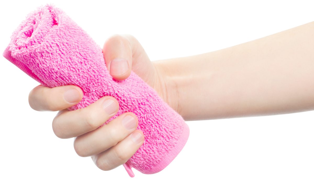 mano sosteniendo un puñado de toalla rosa | Cómo elegir la mejor toalla de entrenamiento para tu gimnasio | toalla de gimnasia | la mejor toalla de ducha