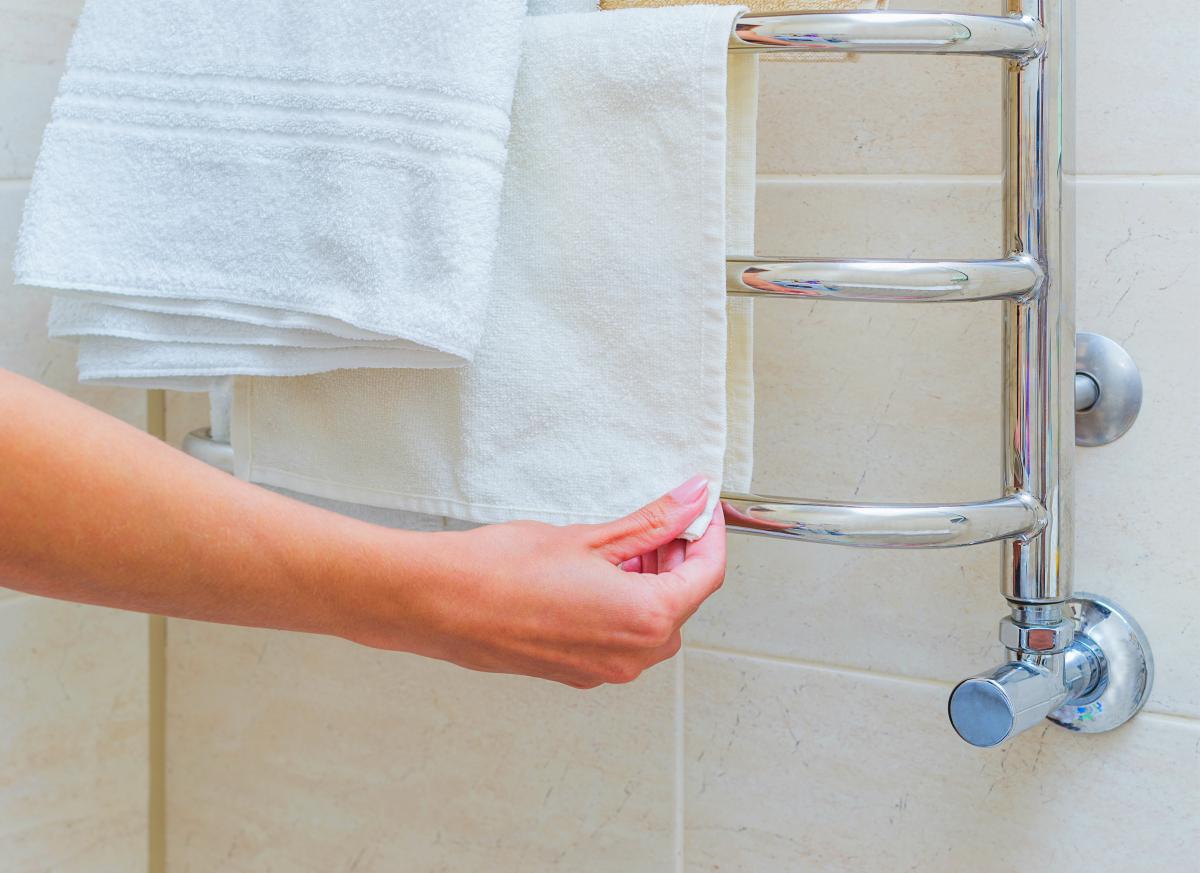 la persona que pone la toalla sobre el calentador de toallas Calentador de toallas: accesorio de baño que no sabía que necesitaba un calentador de toallas | calentador de toallas
